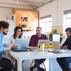 Un grupo de personas colaborando alrededor de una mesa.